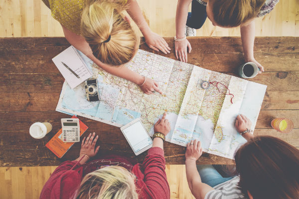 A group of friends plan a motorhome road trip itinerary.