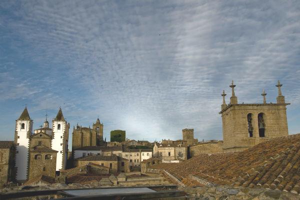 Dawn rises above the medieval architecture of Caceres in Spain.